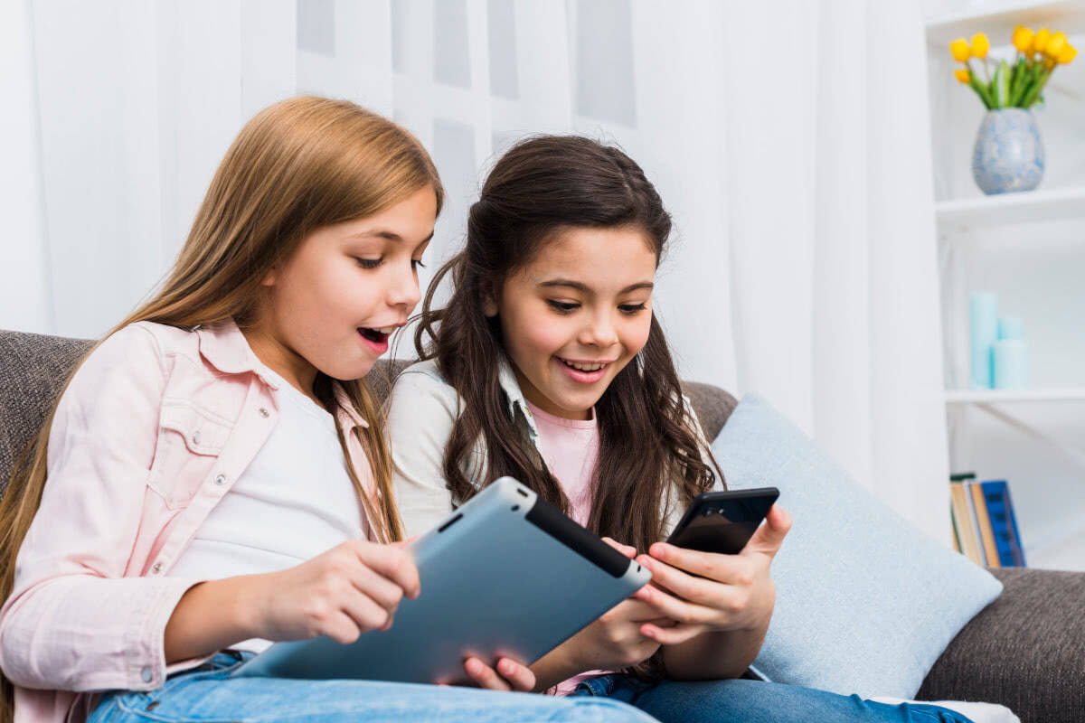 Picture of two young girls immersed into a tablet pc.